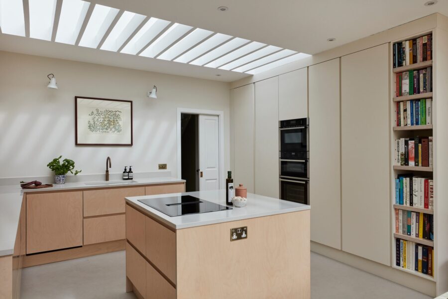 Plywood island kitchen beneath a rooflight